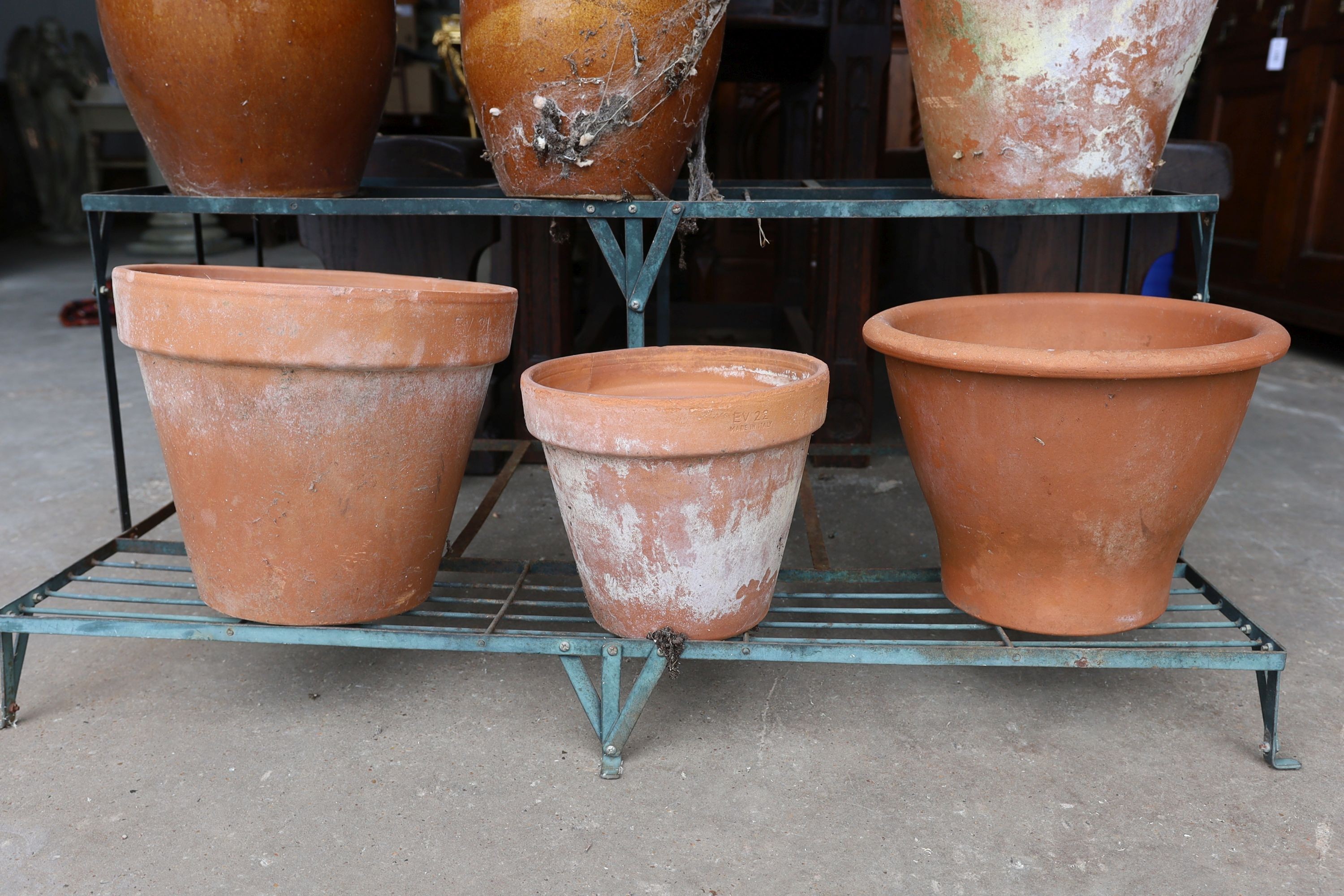 A painted wrought iron three tier pot stand together with a collection of 13 assorted terracotta and pottery pots